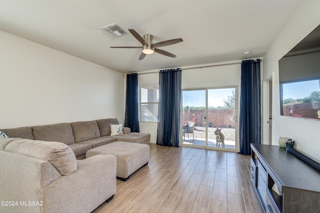 living room with light hardwood / wood-style flooring and ceiling fan