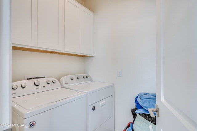 clothes washing area featuring cabinets and washer and dryer