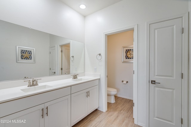 bathroom with vanity, toilet, and hardwood / wood-style flooring