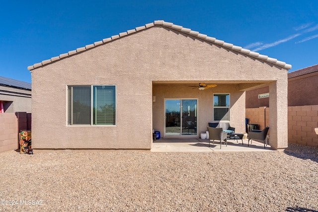 rear view of property featuring ceiling fan and a patio area