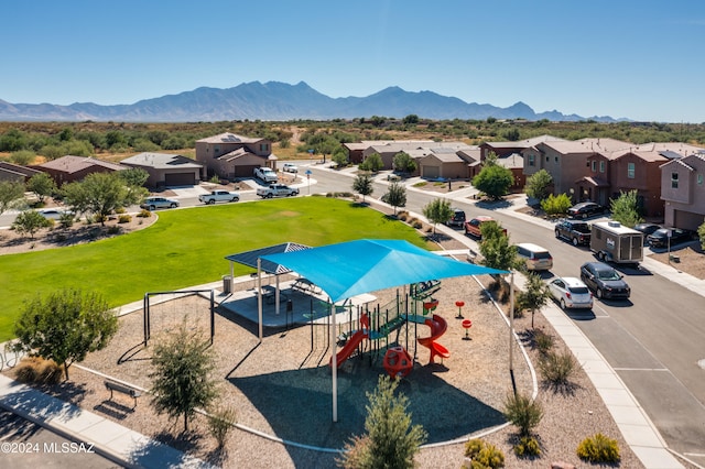 view of pool with a yard, a mountain view, and a playground