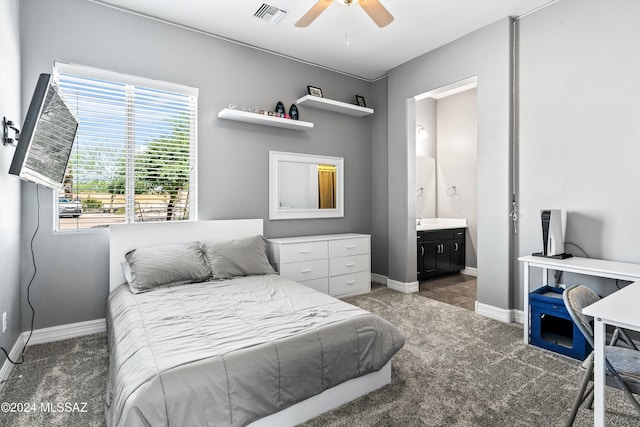 bedroom featuring dark colored carpet, connected bathroom, and ceiling fan