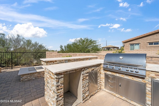 view of patio / terrace featuring an outdoor kitchen and a grill