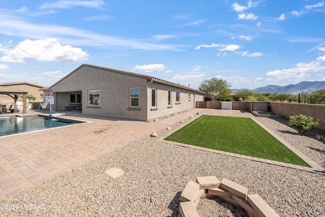 back of house featuring a mountain view, a patio, and a fenced in pool