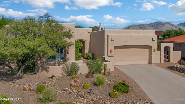 pueblo-style house featuring a mountain view and a garage