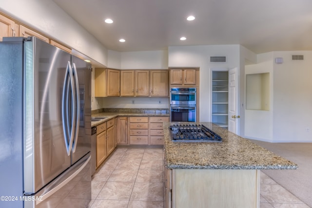 kitchen with light carpet, light stone countertops, stainless steel appliances, and light brown cabinetry