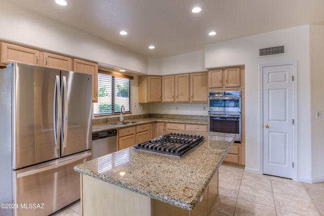 kitchen with light brown cabinets, a center island, and stainless steel appliances