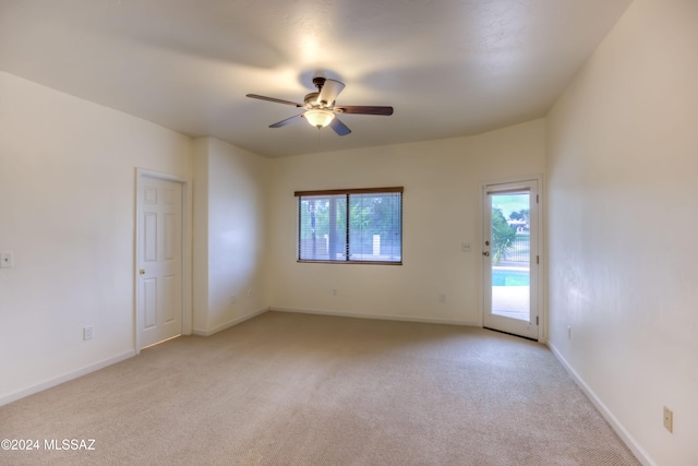 carpeted empty room with ceiling fan and plenty of natural light