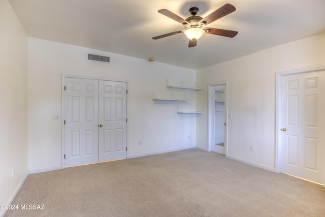 unfurnished bedroom with light colored carpet and ceiling fan