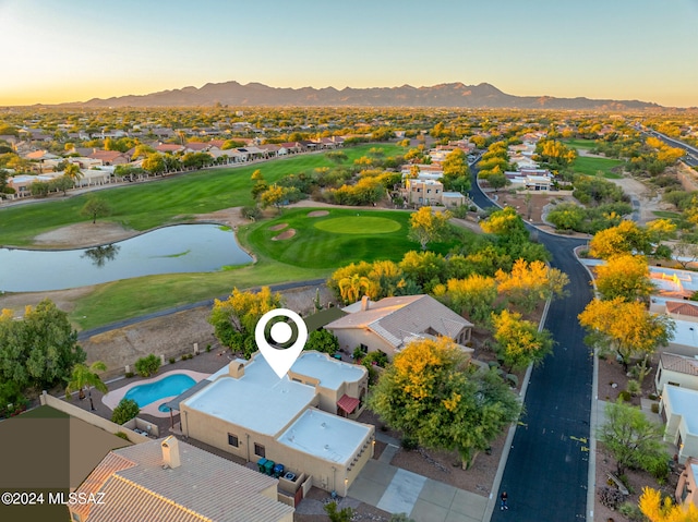 aerial view at dusk featuring a water and mountain view