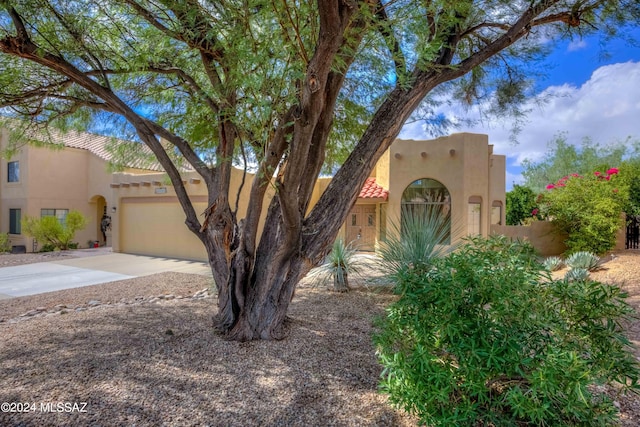 pueblo revival-style home with a garage