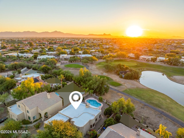 aerial view at dusk featuring a water view