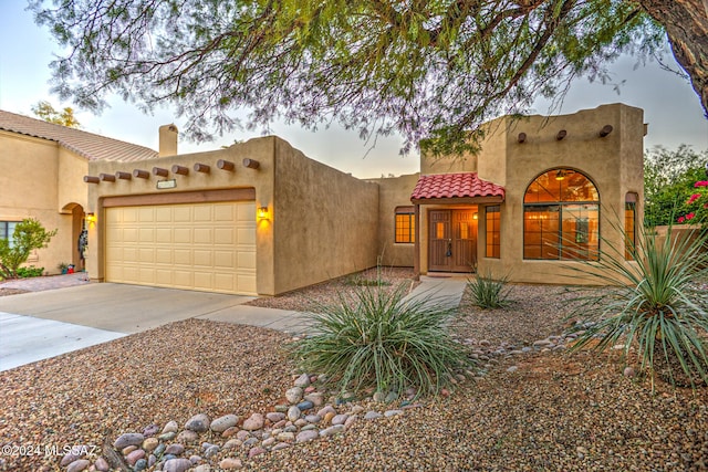 pueblo-style home with a garage