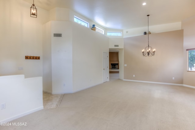 carpeted empty room featuring a high ceiling and plenty of natural light