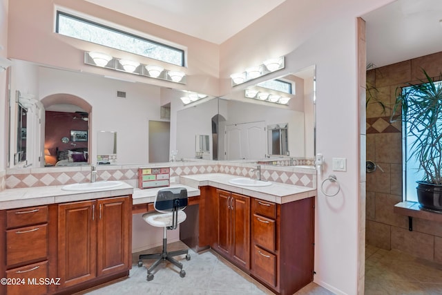 bathroom with vanity, tiled shower, tile patterned floors, and decorative backsplash