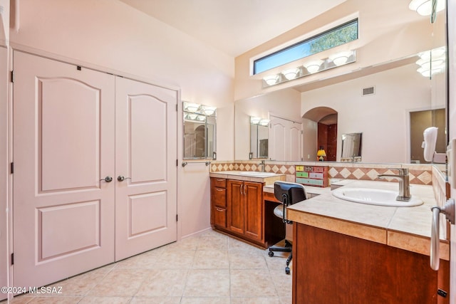 bathroom with tile patterned flooring, vanity, and backsplash