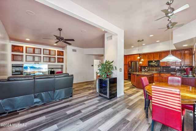 living room featuring hardwood / wood-style flooring, beverage cooler, and ceiling fan