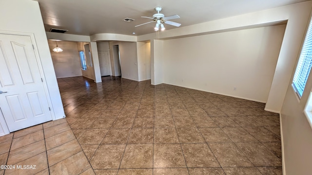 spare room with dark tile patterned floors and ceiling fan