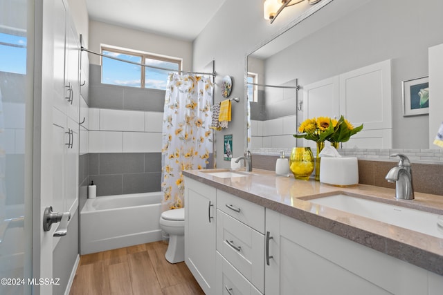 full bathroom featuring vanity, shower / bath combo, hardwood / wood-style flooring, toilet, and decorative backsplash