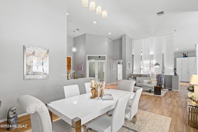 dining room with a high ceiling and light wood-type flooring