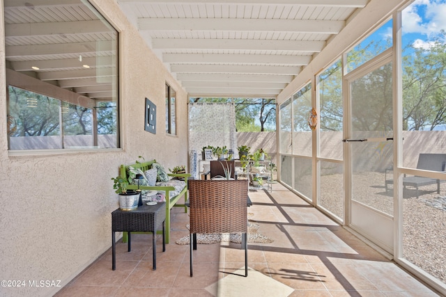 sunroom / solarium featuring beam ceiling