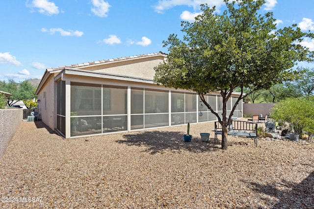 rear view of house featuring a sunroom