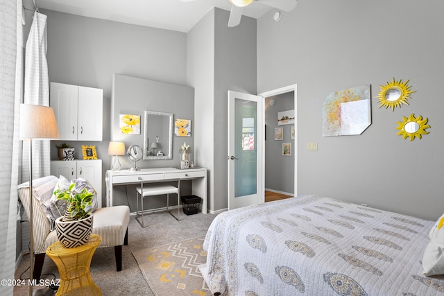 carpeted bedroom featuring a towering ceiling and ceiling fan