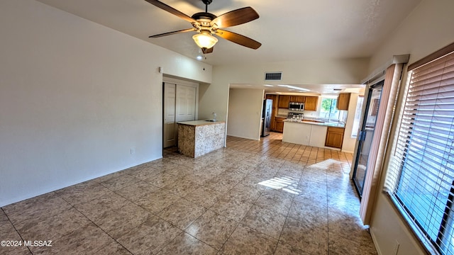 interior space featuring ceiling fan, sink, and light tile patterned floors