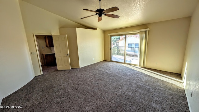 spare room featuring ceiling fan, a textured ceiling, lofted ceiling, and dark colored carpet