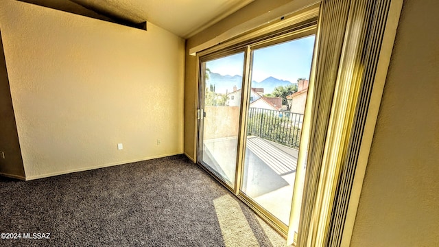 doorway with dark carpet, a mountain view, and lofted ceiling