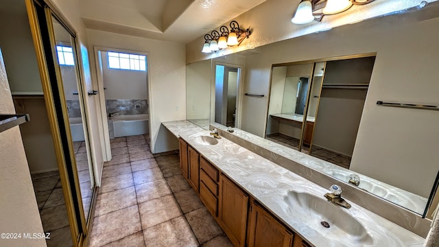 bathroom featuring vanity, tile patterned flooring, and a washtub