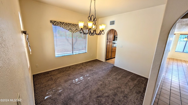 unfurnished dining area with dark colored carpet