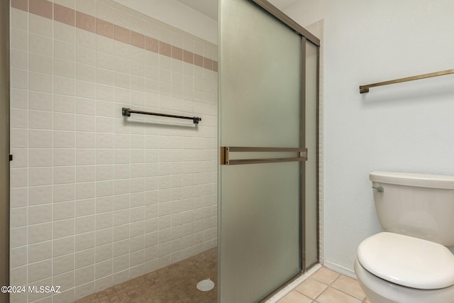 bathroom with a shower with shower door, toilet, and tile patterned flooring