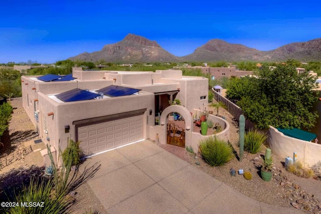 5550 W Open R Pl, Tucson, AZ 85713 - southwest-style home featuring stucco siding, an attached garage, driveway, a mountain view, and roof mounted solar panels