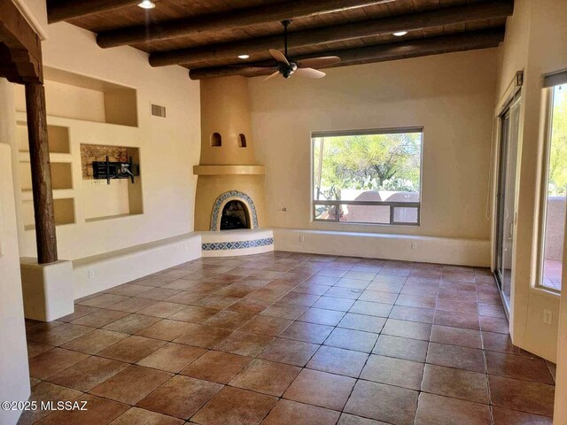 5550 W Open R Pl, Tucson, AZ 85713 - unfurnished living room with wooden ceiling, beamed ceiling, a ceiling fan, and a large fireplace
