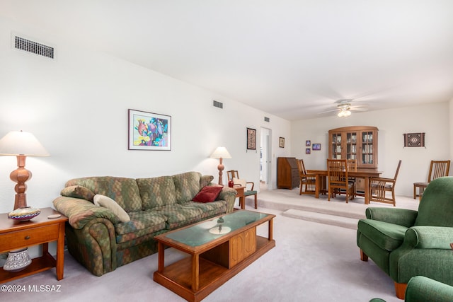 living room with carpet flooring, visible vents, and a ceiling fan