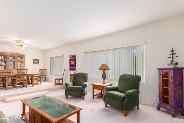 carpeted living area featuring ceiling fan