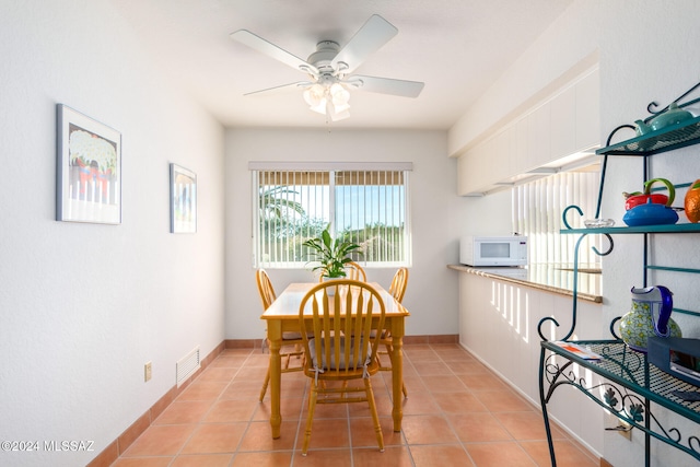 dining area with light tile patterned floors, baseboards, visible vents, and ceiling fan