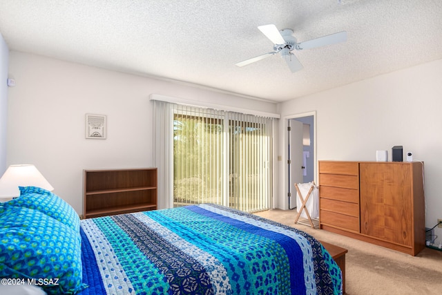 carpeted bedroom with ceiling fan and a textured ceiling