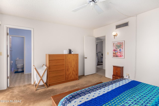 carpeted bedroom featuring visible vents, ceiling fan, a textured ceiling, and ensuite bathroom