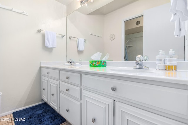 full bathroom with double vanity, visible vents, baseboards, and a sink