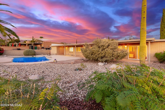 rear view of house with a patio area and an outdoor pool