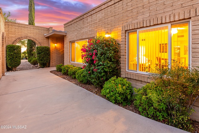 exterior entry at dusk featuring a patio area