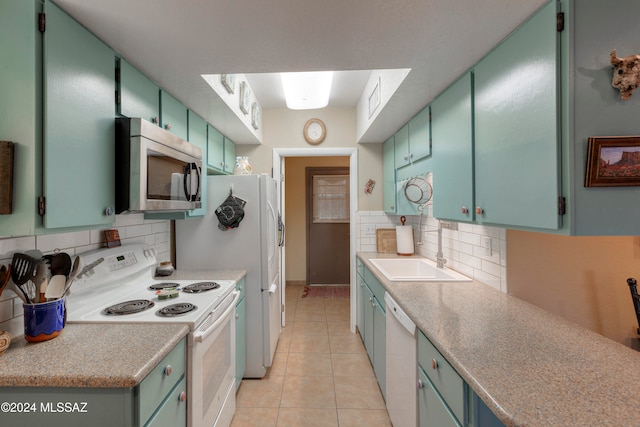 kitchen featuring light tile patterned floors, white appliances, a sink, and tasteful backsplash