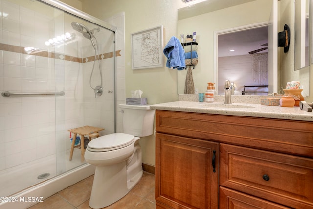 ensuite bathroom featuring a stall shower, tile patterned flooring, vanity, and toilet