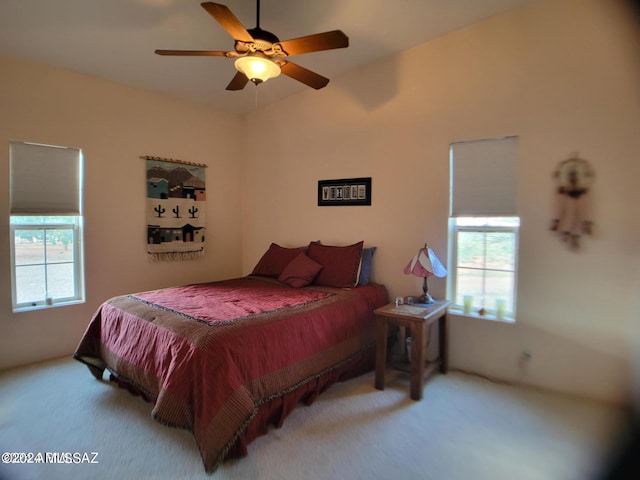 bedroom featuring ceiling fan, carpet floors, and multiple windows