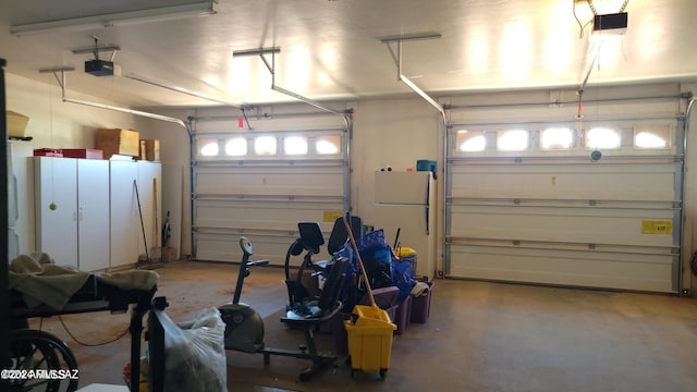 garage featuring a garage door opener and white fridge