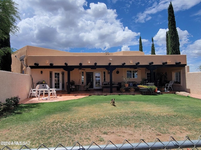 back of property featuring french doors, a patio, a lawn, and ceiling fan