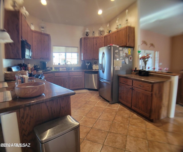 kitchen with light tile patterned flooring, appliances with stainless steel finishes, and sink