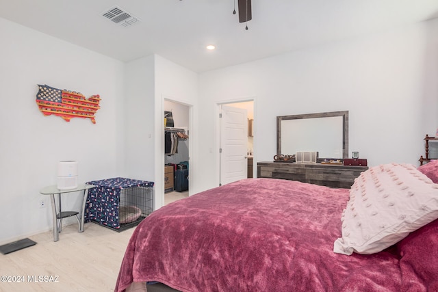 bedroom featuring a closet, hardwood / wood-style floors, a spacious closet, and ceiling fan